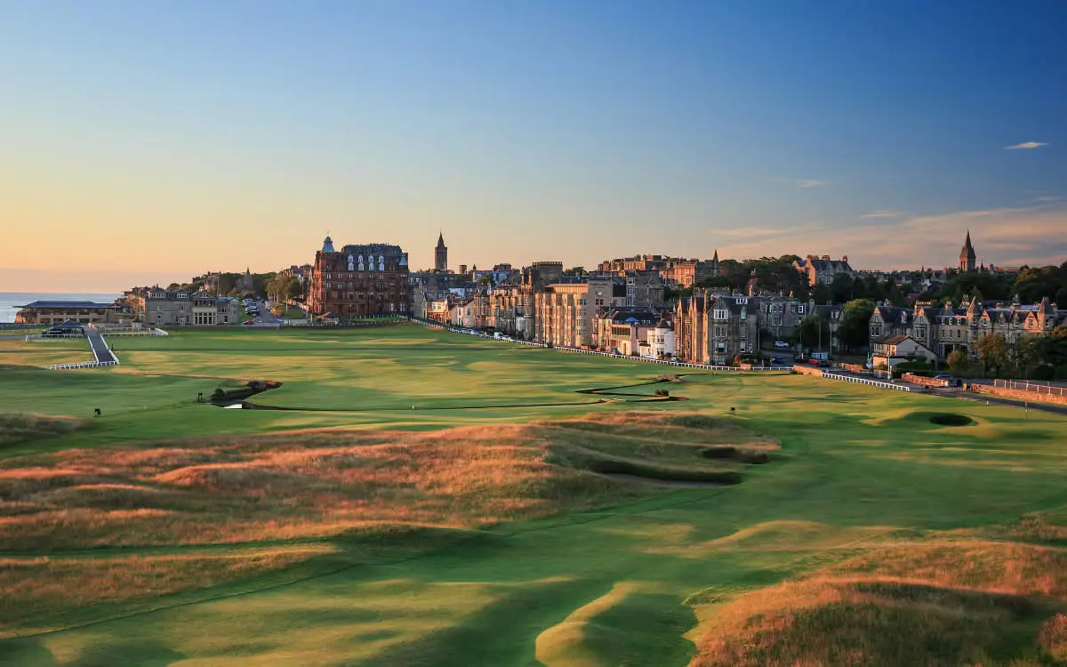 Golf course with historic town in background.