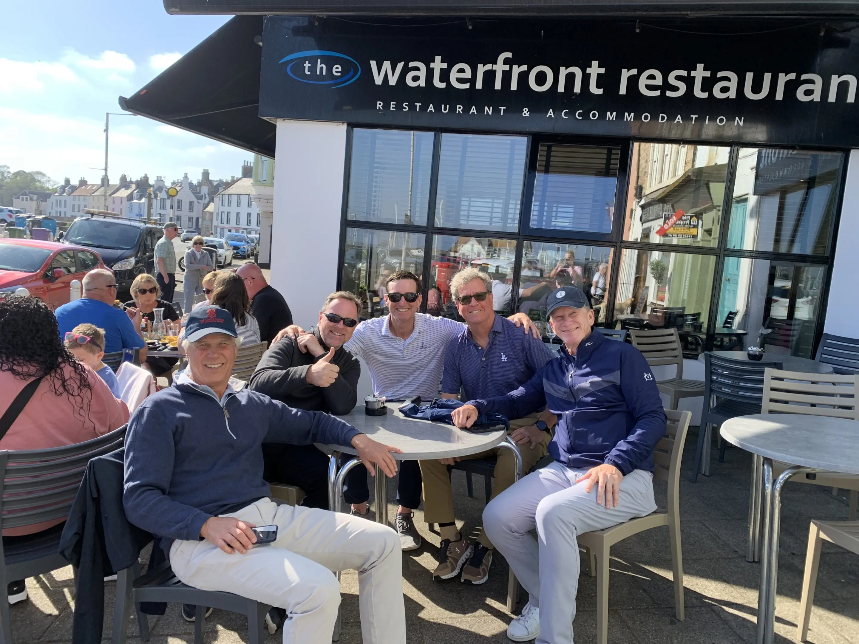 Group of people outside the waterfront restaurant.