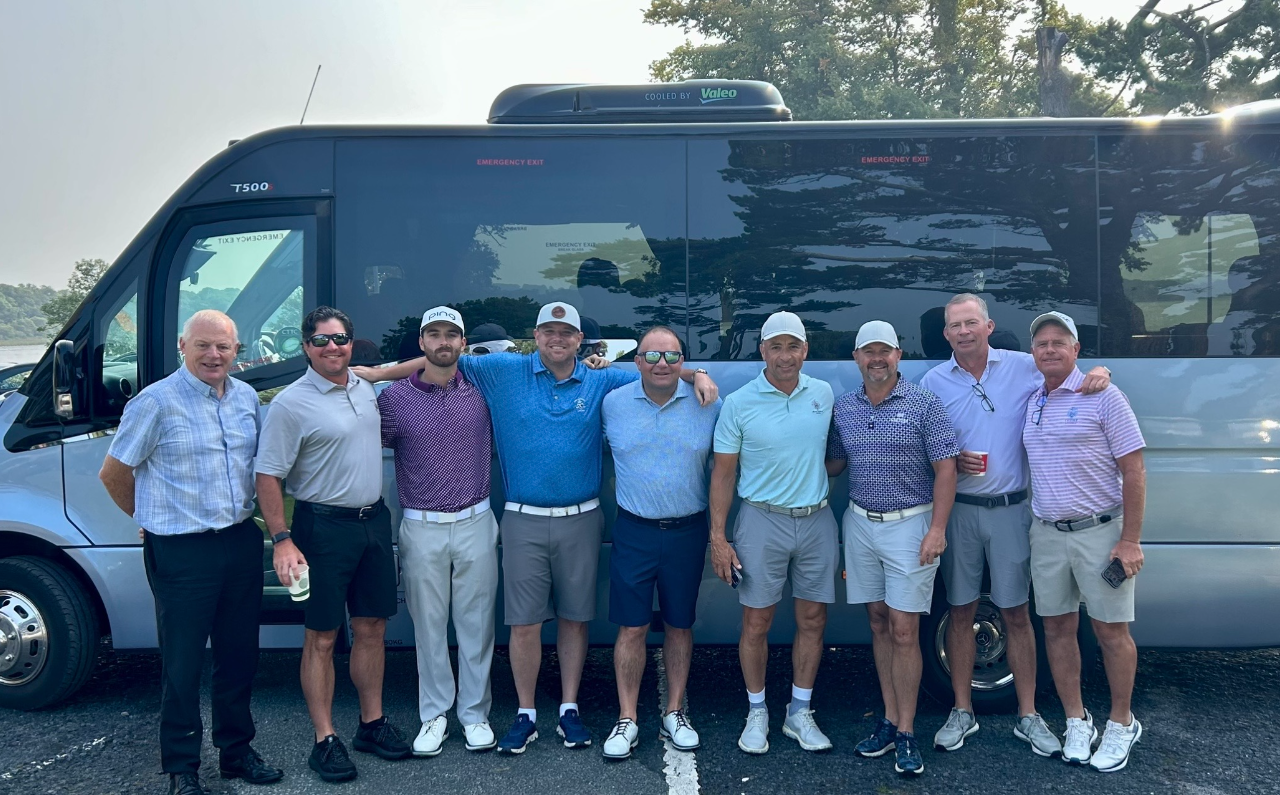 Group of men standing by a van.
