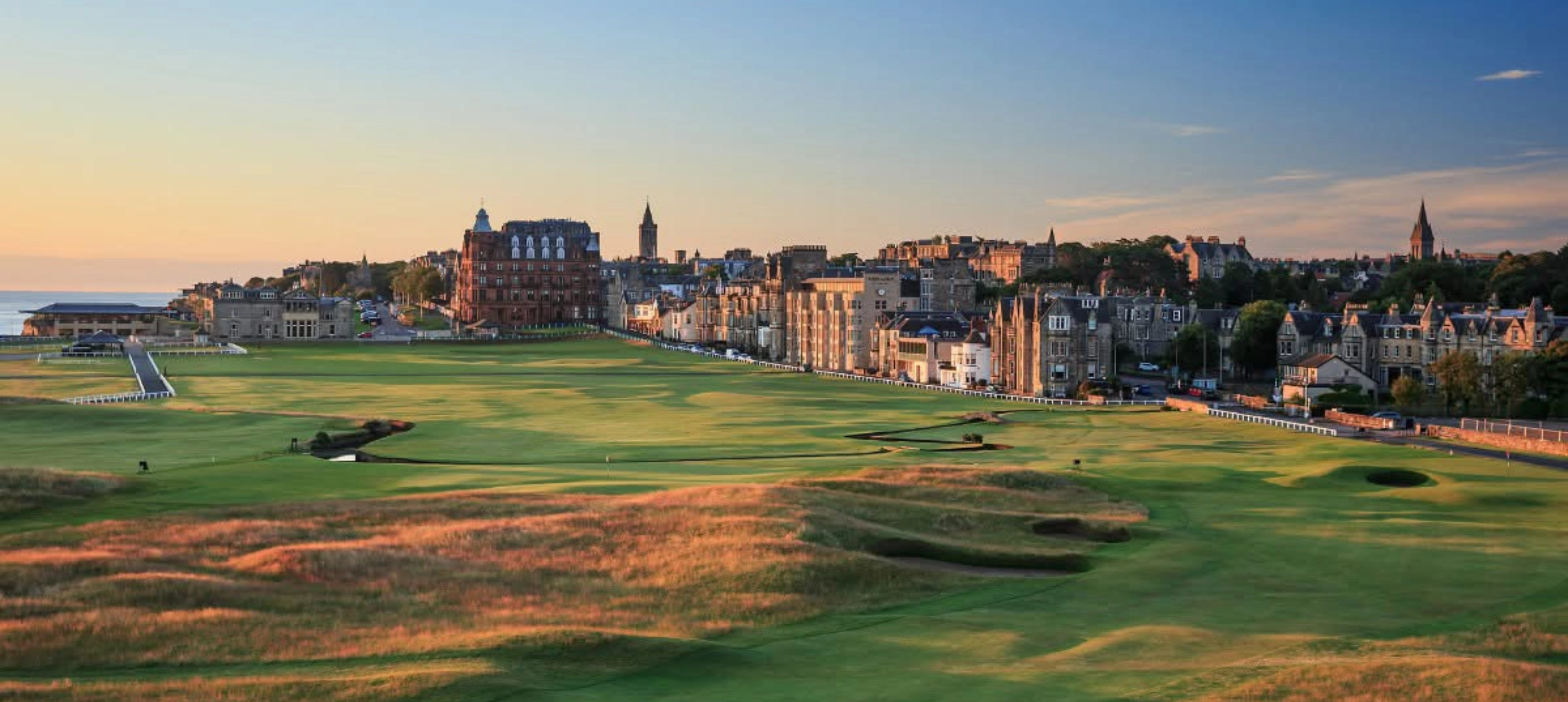 Historic golf course with town and sunset view.