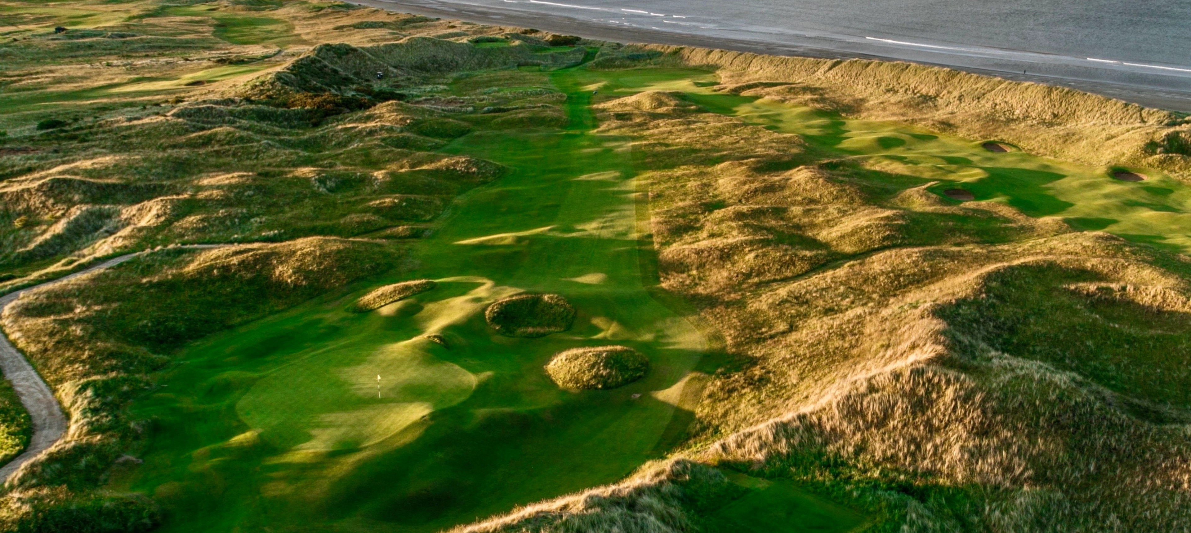 Aerial view of coastal golf course landscape.